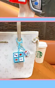 Primer plano de un llavero azul de tecla de teclado en un bolso de diseño blanco.