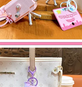 Close-up of pink and purple cartoon camera projector keychain as a creative bag charm