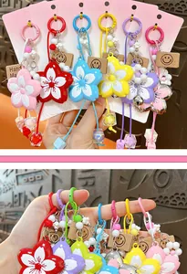 Macro detail of colorful flower keychains with braided rope and smiley face tags