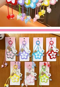 Detailed view of colorful alloy flower keychains with woven ropes and smiley tags for bags