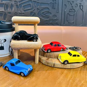 Set van vintage lichtmetalen auto-sleutelhangers in vier kleuren op houten rekwisieten