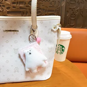 Cute plush bear keychain with portable folding mirror hanging on a white tote bag