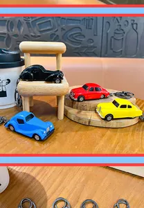 Close-up van vier kleurrijke creatieve legering vintage auto sleutelhangers op hout