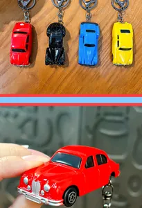 Detailopname van een rode vintage beetle-stijl autosleutelhanger met metalen ring