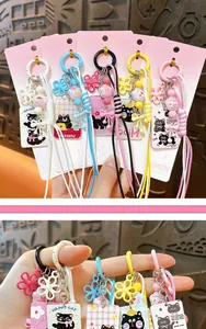 Macro view of various cute cat keychains featuring colorful braided cords and charms