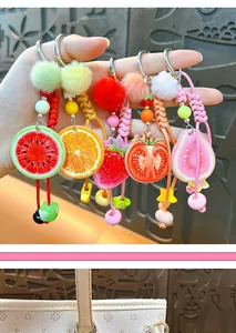 Gros plan de porte-clés tranches de fruits colorés avec pompons pour décoration