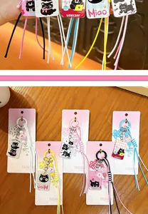 Creative cute cartoon cat bag charms and keychains displayed on pink cards over wood