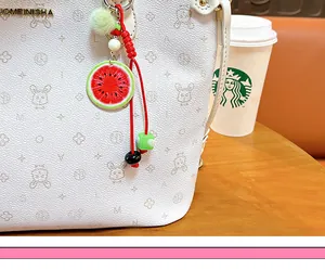 Vue détaillée d'un charm de tranche de pastèque réaliste sur un accessoire de sac blanc