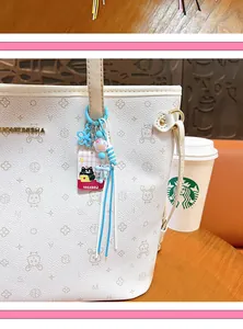Detailed view of a creative cute cat bag charm keychain with blue tassels on a bag