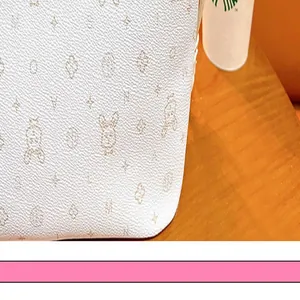 Detailaufnahme des weißen Taschenanhängers mit niedlichem Bären- und Sternenmuster