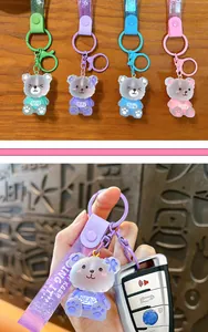 Close-up of cute translucent purple bear keychain with glittery strap on car key
