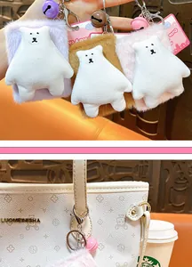 Close-up detail of a cute pink plush bear mirror keychain hanging on a white tote bag charm.