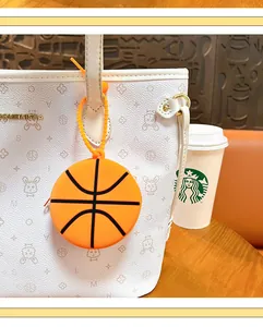 Close-up of basketball-shaped silicone coin purse hanging on a white tote bag