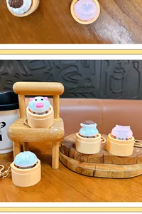 Detailed macro view of colorful glowing Xiaolongbao keychains on miniature wooden props.