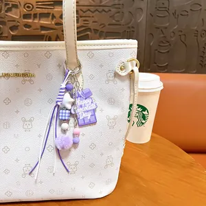 Kreativer lila Schokoriegel- und Bommel-Taschenanhänger für Schultaschen und Schlüssel