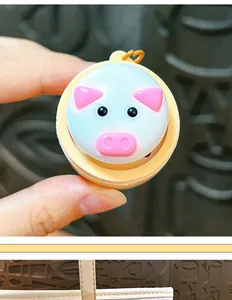 Close-up of a creative glowing pig-shaped button keychain toy for stress relief