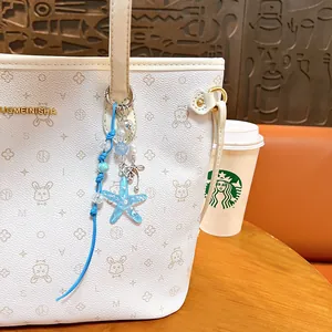 Blue acrylic starfish keychain charm on white tote bag with ocean theme style accessories