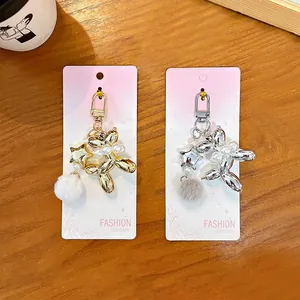 Premium metallic balloon dog keychains featuring elegant pearl charms and soft fur balls