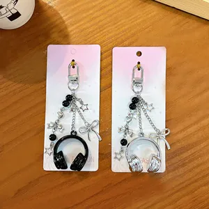 Portachiavi cuffie musicali stile Y2K con ciondoli a stella e fiocco in argento