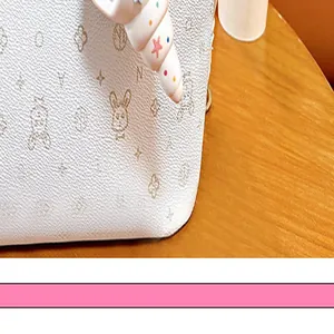 Détail d'un porte-clés en forme de coquillage coloré sur un sac à main blanc texturé