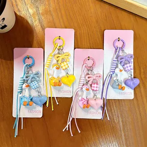 Set of four cute cartoon pajama duck keychains with colorful heart and bow charms for bags.