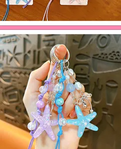 Close-up of sparkling acrylic starfish bag charms with colorful beads held in hand.