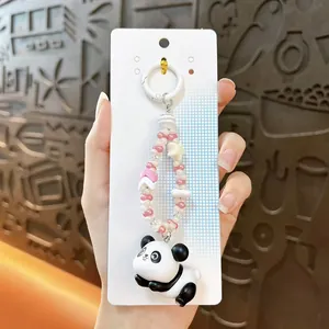 Close-up detail of a cute 3D cartoon panda keychain with pink and white beaded strap charm