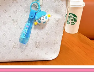 Gros plan d'un mignon porte-clés football bleu accroché à un sac à motifs blancs.