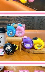 Variety of colorful snail-shaped musical keychains displayed on mini wooden furniture props.