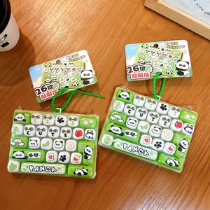 Creative 26-key panda mechanical keyboard fidget toy keychain on wooden table background