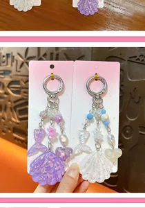 Vue détaillée des porte-clés en acrylique irisé avec coquillage et queue de sirène