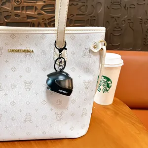 Creative mini glowing motorcycle helmet keychain used as a cute white tote bag charm