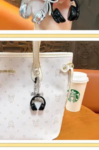 Dettaglio macro di un ciondolo per borsa mini cuffie nero con catenella in metallo.
