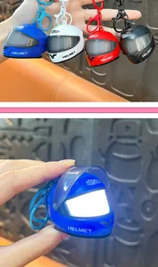 Detail of mini blue helmet keychain showing glowing LED light and movable shield