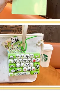 Detailed macro view of a cute panda mechanical keyboard fidget toy hanging on a white tote bag.