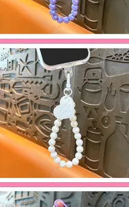 Close-up detail of white iridescent beaded phone strap featuring an embossed heart charm
