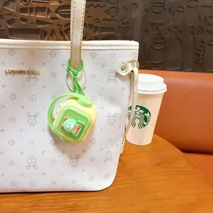 Retro mini speaker keychain toy in light green and yellow hanging on a white bag