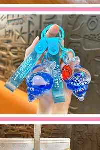 Detail of blue shell keychains with floating dolphin and clownfish inside oil charms