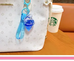 Close-up view of blue conch keychain with flowing oil and star glitter charms on bag