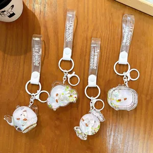 Cute creative sheep liquid quicksand keychains in teapot and candy shapes on wood table