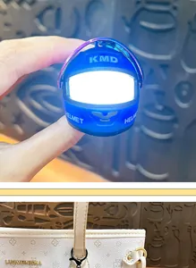 Vista dettagliata di un portachiavi a forma di casco da moto blu brillante su una borsa.