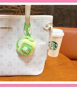 Mini retro radio recording speaker keychain charm hanging on a cream patterned tote bag