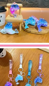 Detail view of colorful dolphin liquid glitter keychains with 'Just Keep Doing It' straps.