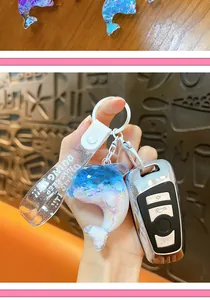 Close-up of a creative liquid quicksand dolphin keychain attached to a car key.