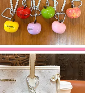 Detail view of colorful apple resin keychains with pearl bead chains and heart clips