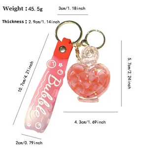 Creative pink heart perfume bottle keychain with liquid bubbles and a stylish pink strap.