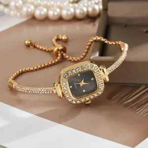 Nahaufnahme einer eleganten quadratischen Golduhr mit Diamantlünette und Zugband