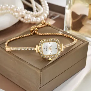 Detailansicht einer goldfarbenen Damenuhr mit Strasssteinen und Bolo-Armband