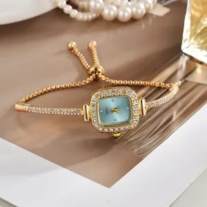Detailaufnahme der eleganten goldenen Armbanduhr mit blauem Zifferblatt und Strasssteinen