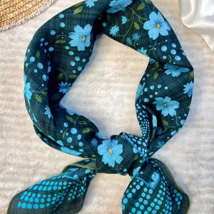 Dark green floral cotton scarf with blue flower pattern in an elegant knot style